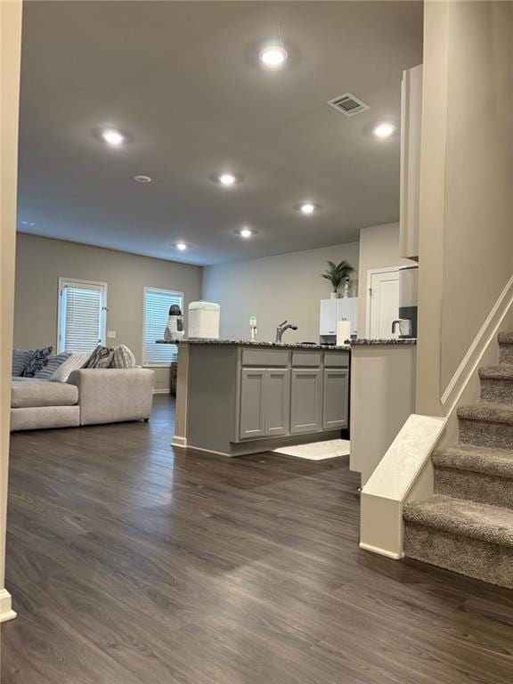 kitchen featuring dark stone counters, dark wood-style flooring, visible vents, and recessed lighting