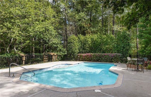 view of swimming pool featuring a patio area and a hot tub