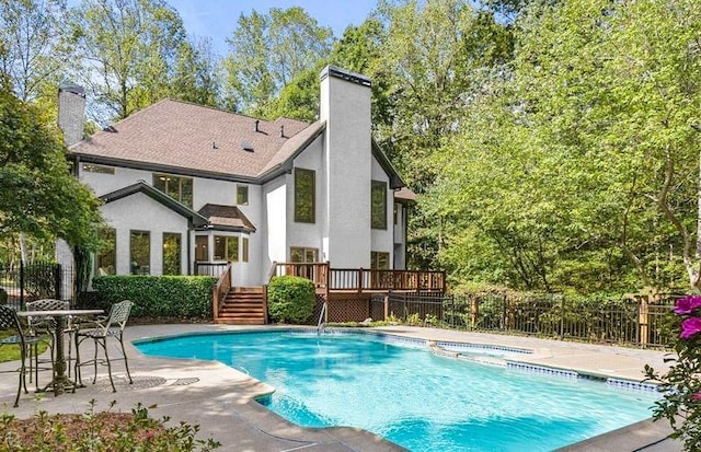 view of swimming pool with a wooden deck, an in ground hot tub, and a patio