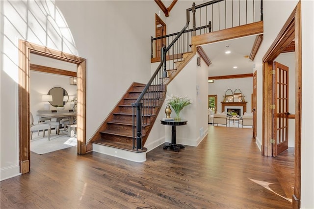 stairs featuring hardwood / wood-style flooring and a high ceiling