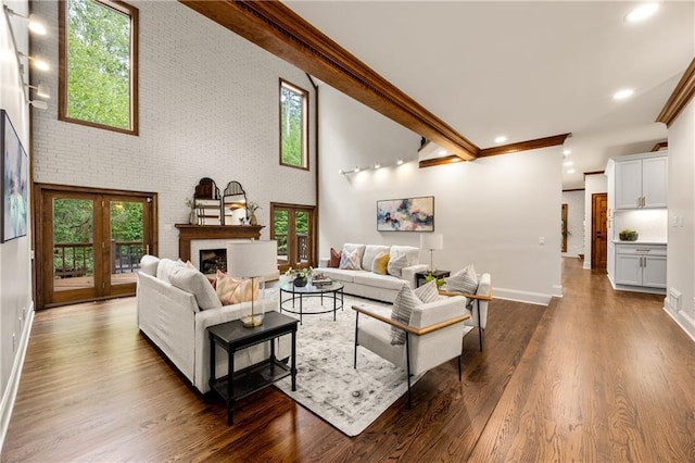 living room featuring a high ceiling, crown molding, brick wall, and dark hardwood / wood-style flooring