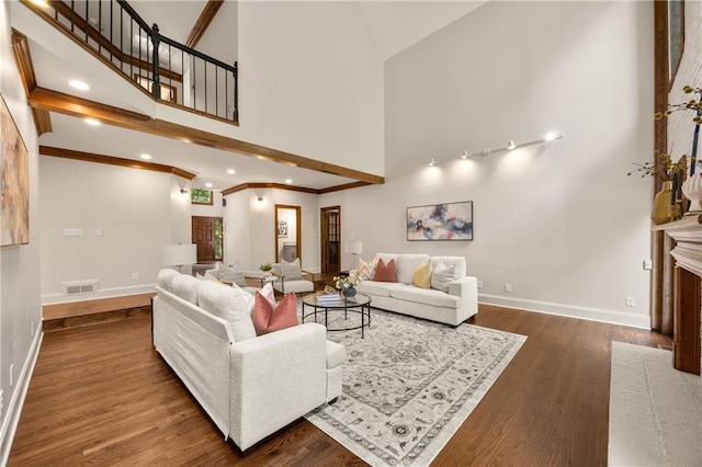 living room featuring a towering ceiling and dark hardwood / wood-style flooring