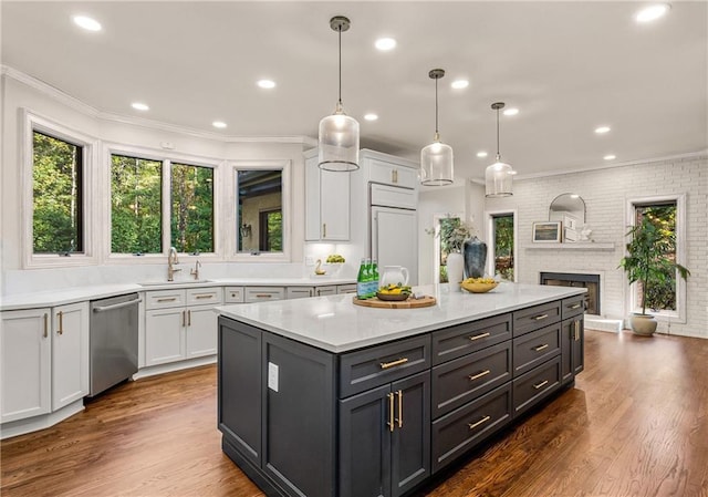 kitchen featuring stainless steel dishwasher, white cabinets, and decorative light fixtures