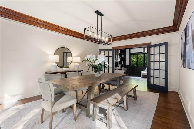 dining area featuring crown molding, dark wood-type flooring, a notable chandelier, and french doors