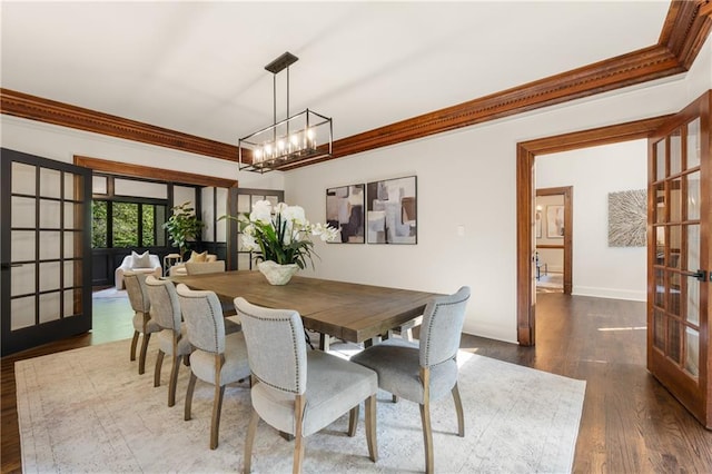 dining room featuring a notable chandelier, dark hardwood / wood-style floors, ornamental molding, and french doors