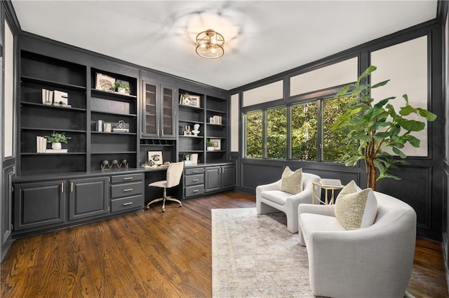 office area with dark hardwood / wood-style floors and built in desk