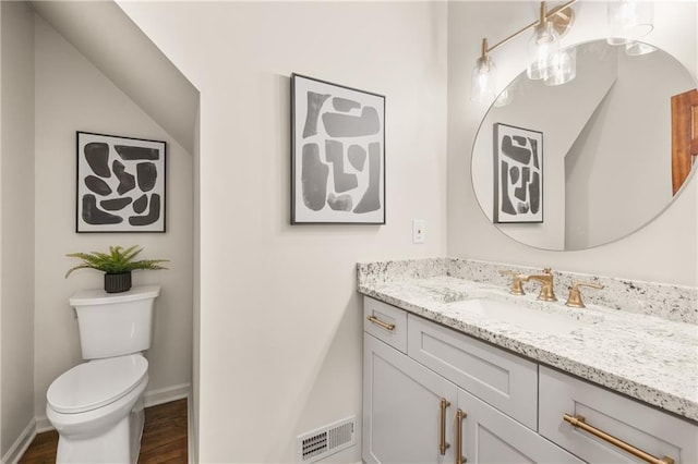 bathroom with vanity, toilet, and hardwood / wood-style floors