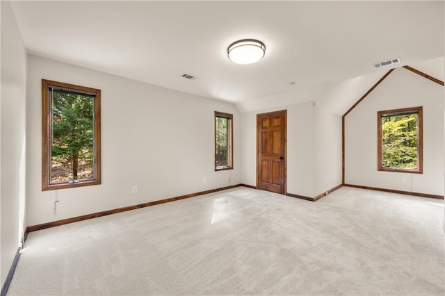 carpeted spare room with lofted ceiling