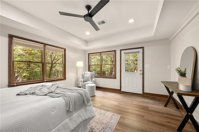 bedroom featuring a tray ceiling, wood-type flooring, and ceiling fan