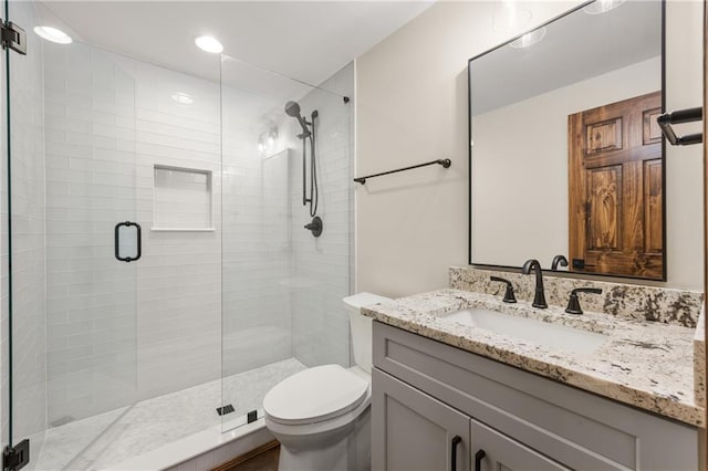 bathroom with vanity, toilet, and a shower with shower door