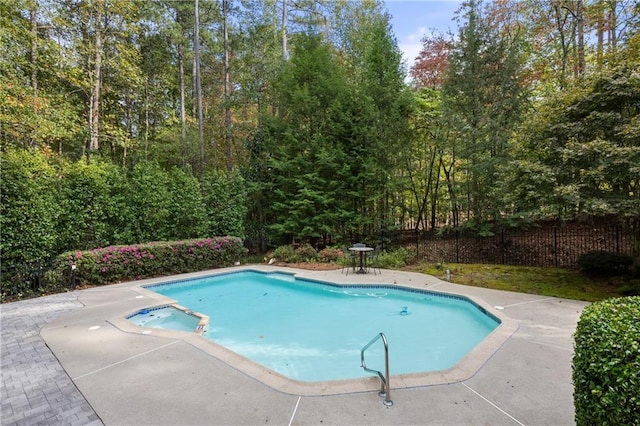 view of swimming pool featuring an in ground hot tub and a patio area