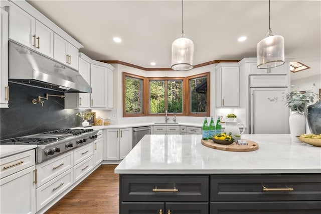 kitchen featuring hanging light fixtures, appliances with stainless steel finishes, sink, and white cabinets