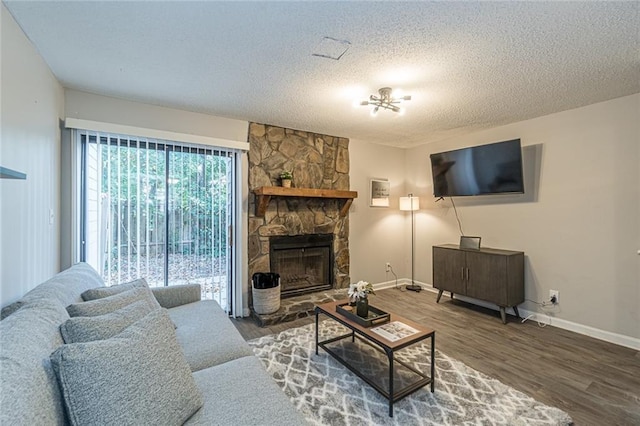 living room featuring a textured ceiling, hardwood / wood-style flooring, and a fireplace