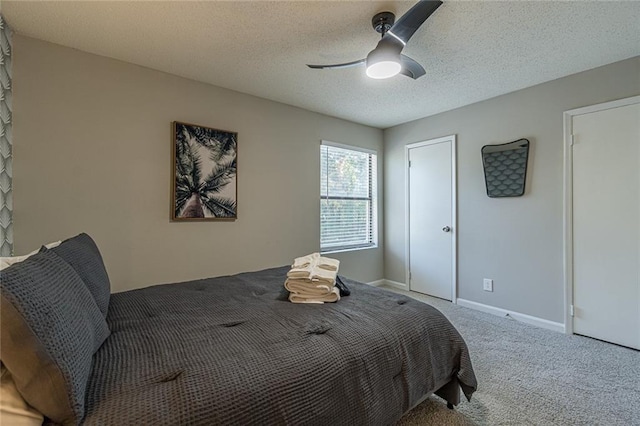 bedroom with ceiling fan, a textured ceiling, and carpet floors