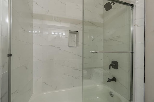 bathroom featuring combined bath / shower with glass door