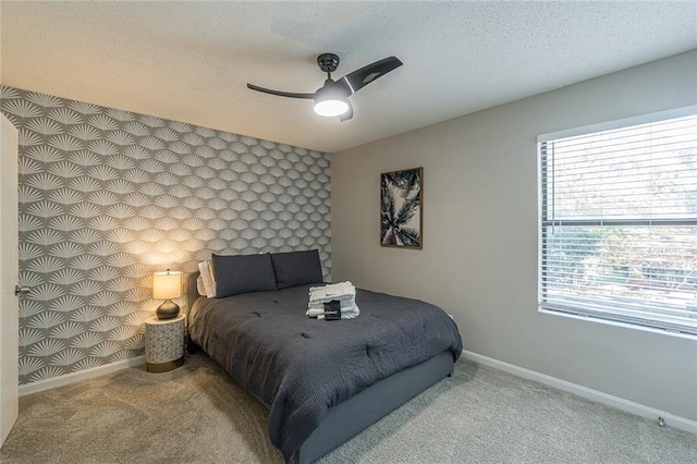 carpeted bedroom featuring a textured ceiling and ceiling fan