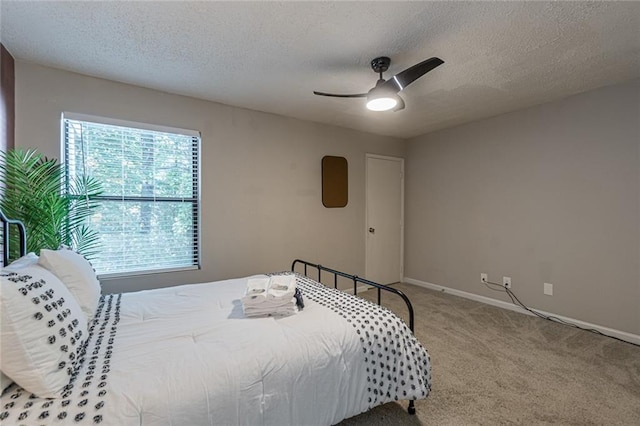 carpeted bedroom with a textured ceiling and ceiling fan