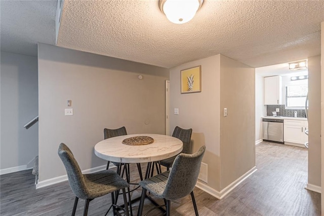 dining room with a textured ceiling and wood-type flooring