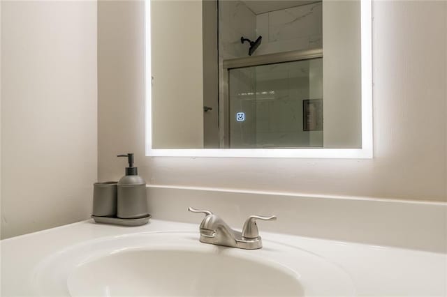 bathroom with sink and an enclosed shower