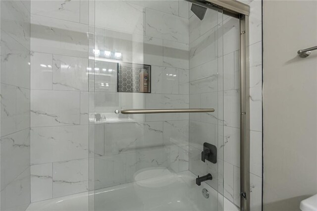 bathroom featuring toilet and enclosed tub / shower combo