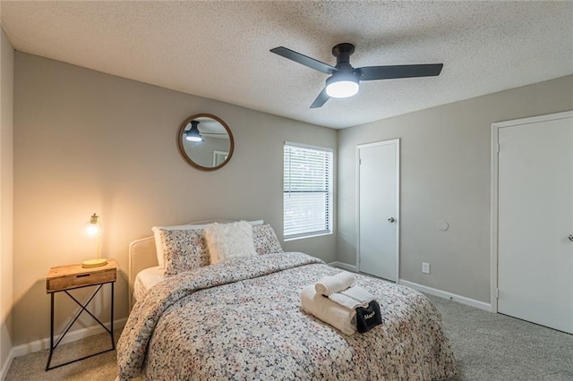 carpeted bedroom featuring a textured ceiling and ceiling fan