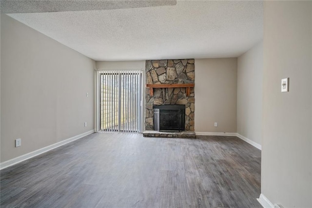 unfurnished living room with dark wood-type flooring, a fireplace, and a textured ceiling