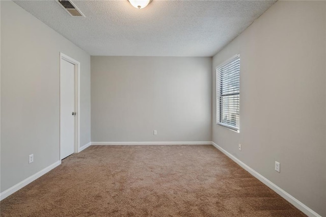 unfurnished room with a textured ceiling and carpet floors