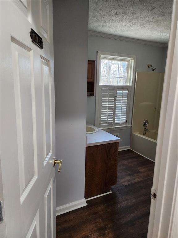 bathroom featuring shower / bathtub combination, vanity, hardwood / wood-style floors, and a textured ceiling