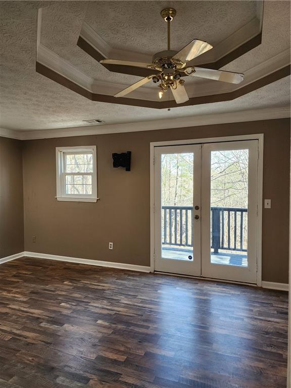 unfurnished room featuring crown molding, dark wood-type flooring, a textured ceiling, and french doors