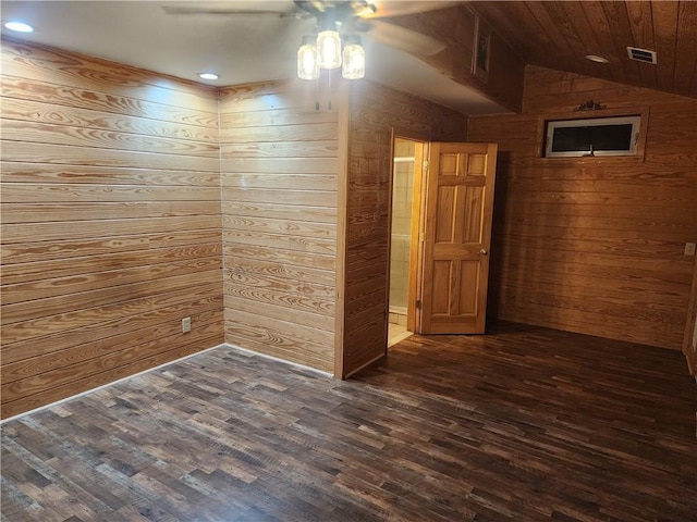 unfurnished room with dark wood-type flooring, ceiling fan, vaulted ceiling, and wood walls