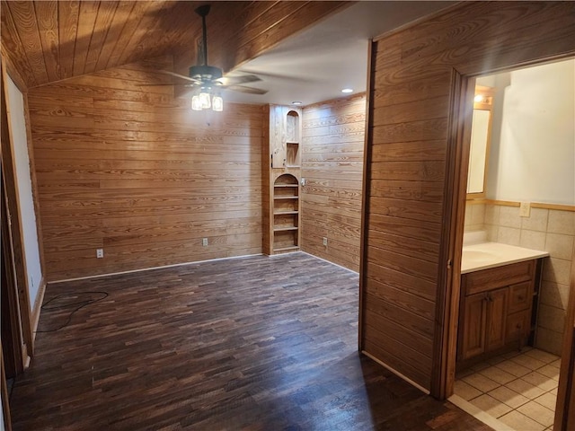 spare room featuring lofted ceiling, wood ceiling, ceiling fan, hardwood / wood-style floors, and wooden walls