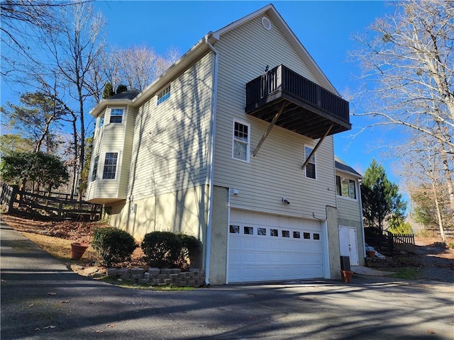 view of property exterior with a garage and a balcony