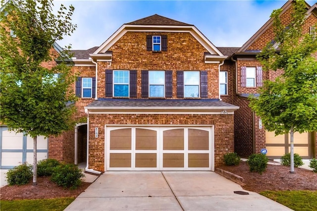 view of front facade with driveway, a garage, and brick siding