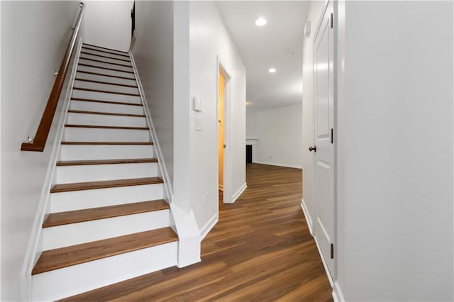 staircase featuring recessed lighting, wood finished floors, and baseboards