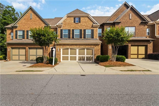 view of front of property featuring a garage, driveway, and brick siding