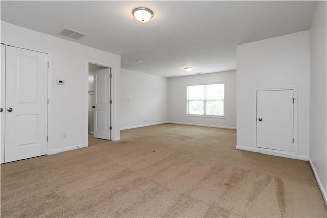 spare room featuring carpet and baseboards