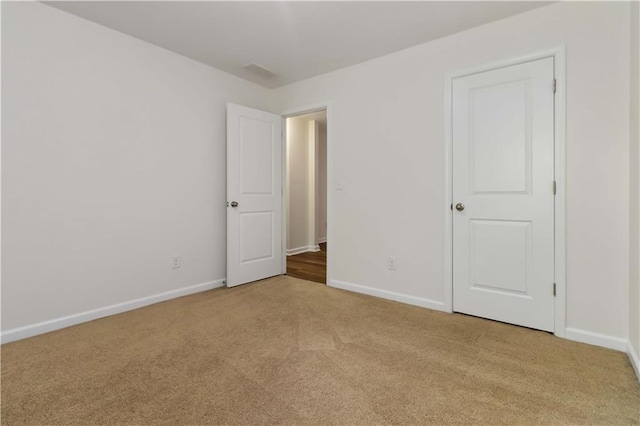unfurnished bedroom featuring carpet and baseboards