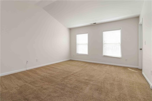 spare room with carpet, baseboards, plenty of natural light, and lofted ceiling