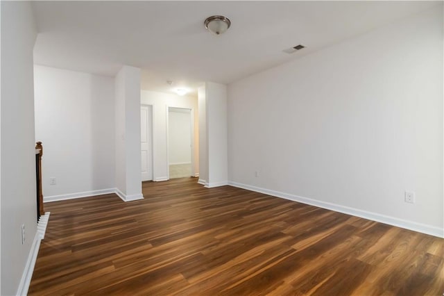 empty room featuring dark wood-style floors and baseboards