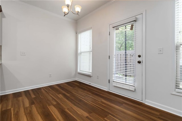 unfurnished room featuring a chandelier, dark wood-style floors, baseboards, and crown molding