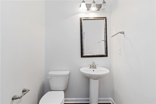 bathroom featuring toilet and baseboards