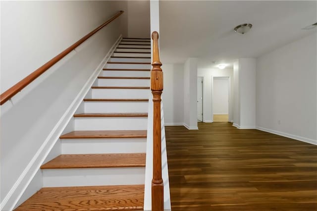 stairway with wood finished floors and baseboards