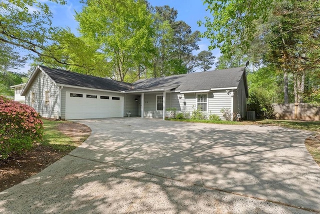 ranch-style house with driveway, an attached garage, central air condition unit, and fence