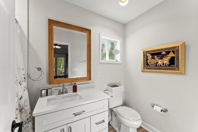 bathroom with toilet, vanity, and curtained shower