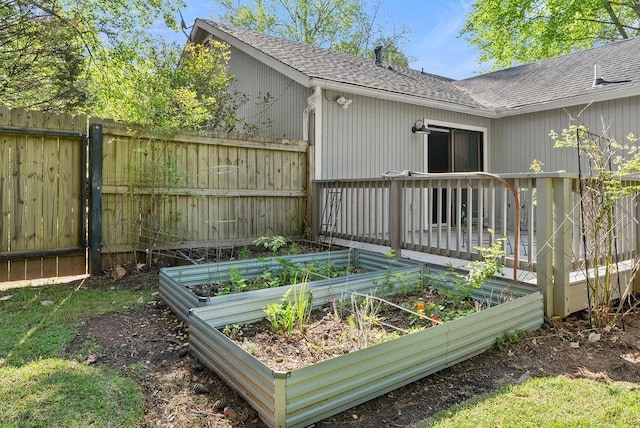 deck with fence and a vegetable garden