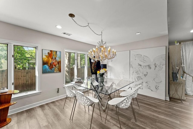 dining space featuring wood finished floors, a chandelier, plenty of natural light, recessed lighting, and baseboards