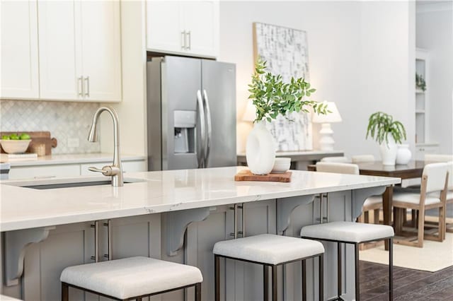 kitchen with white cabinetry, stainless steel refrigerator with ice dispenser, dark wood-style flooring, and a sink