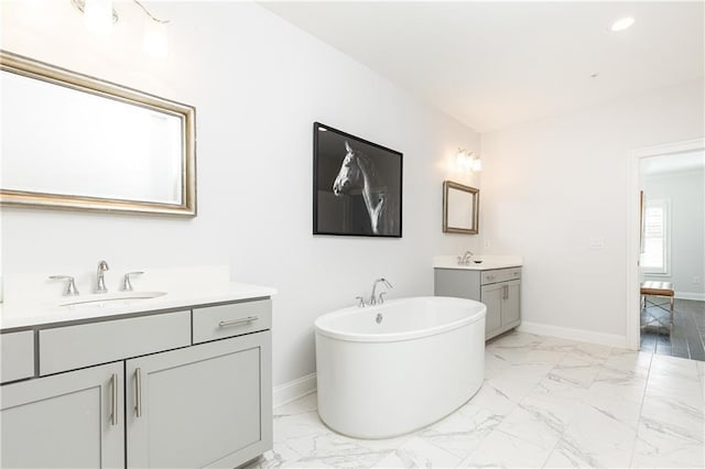 full bathroom featuring a sink, baseboards, two vanities, and marble finish floor