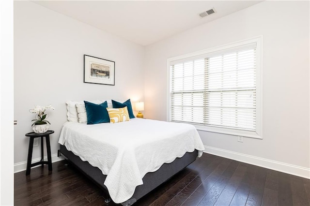 bedroom with hardwood / wood-style flooring, baseboards, and visible vents