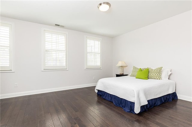 bedroom with hardwood / wood-style floors, baseboards, and visible vents